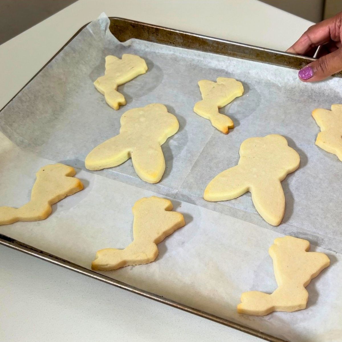 Baked sugar cookies with Powdered Sugar on the baking tray.