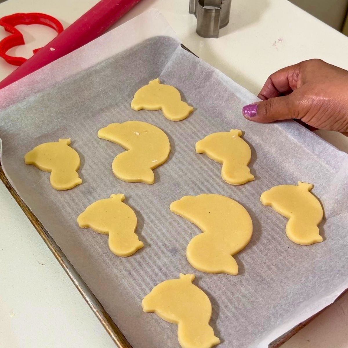 A baking tray with chick shaped cookies.