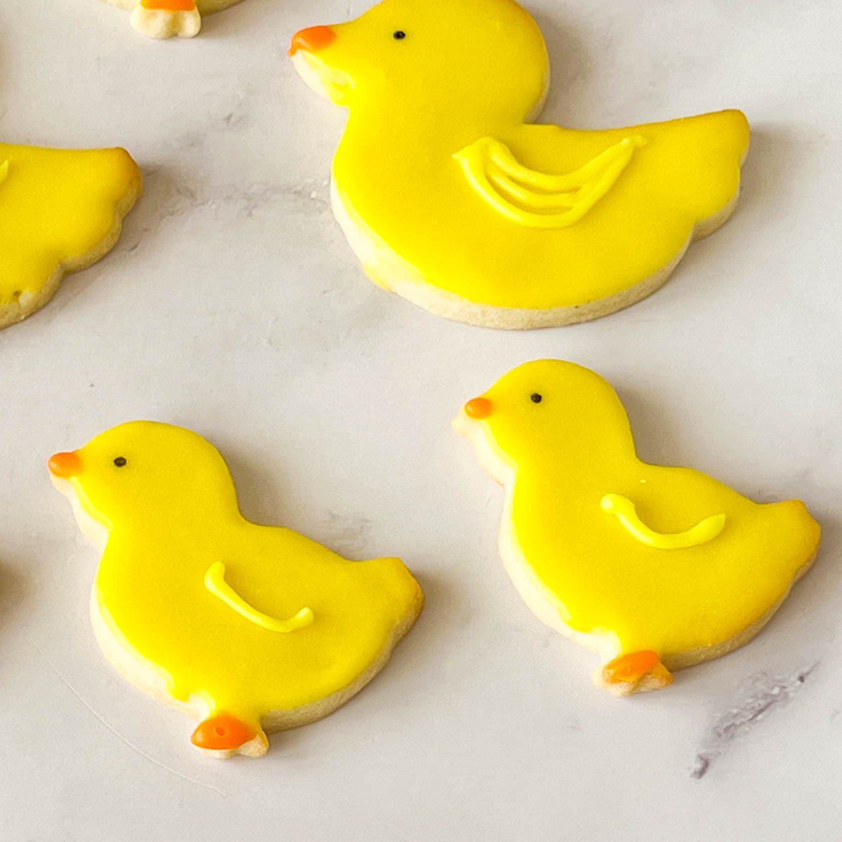 Frosted yellow sugar cookies on the table.
