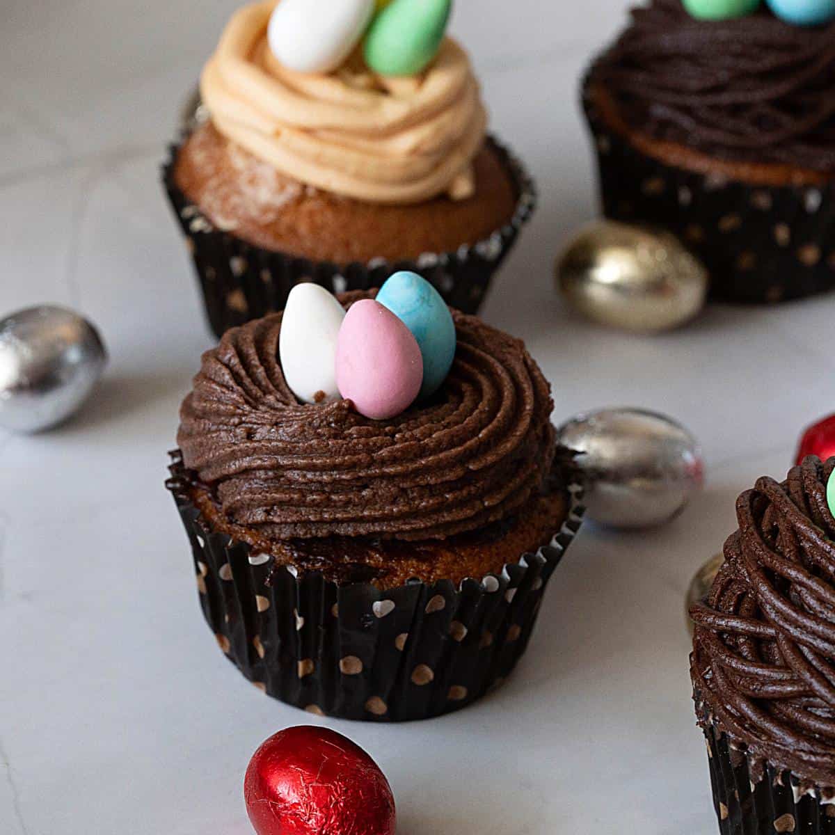 A coconut cupcake with frosted candy eggs.