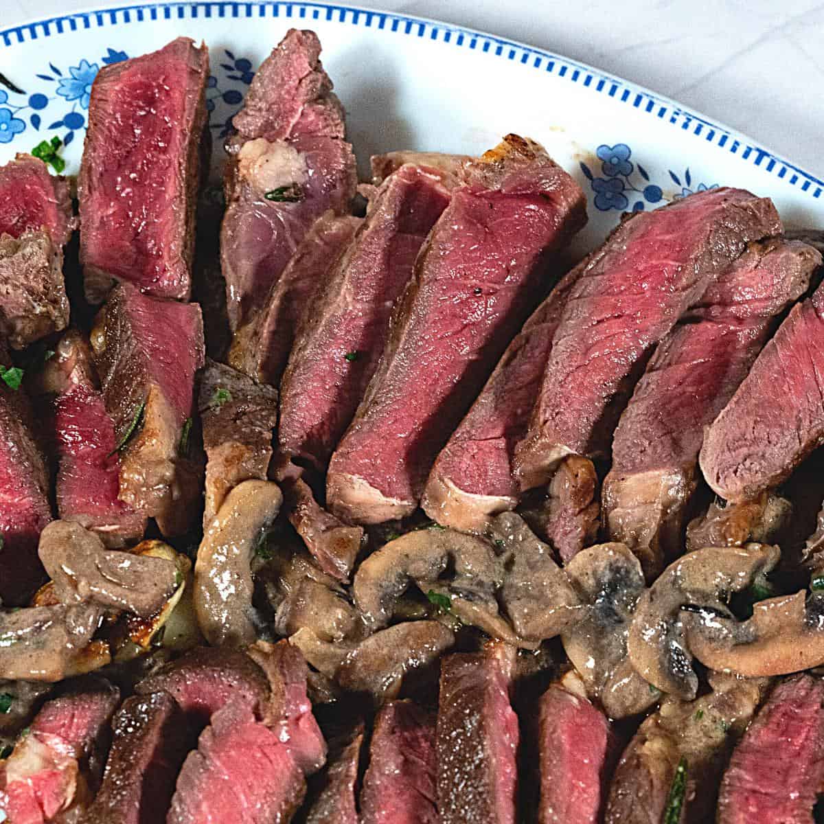 Med rare steak sliced on a platter.