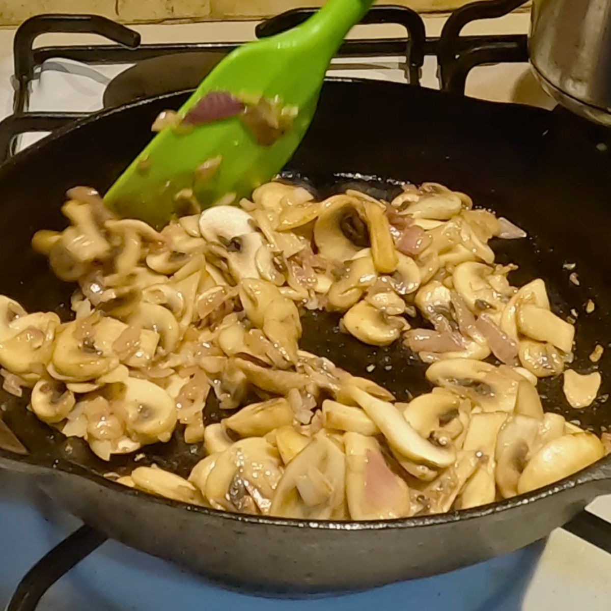 A cast iron skillet with mushroom for steak sauce.