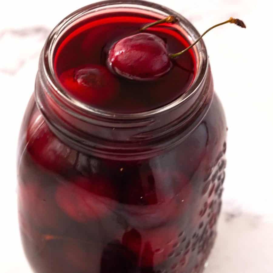 Mason jar with soaked cherries.