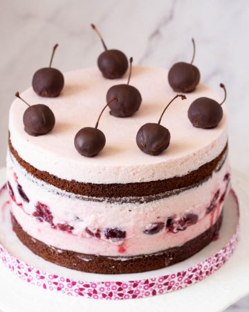 A chocolate cherry mousse cake on the cake stand.