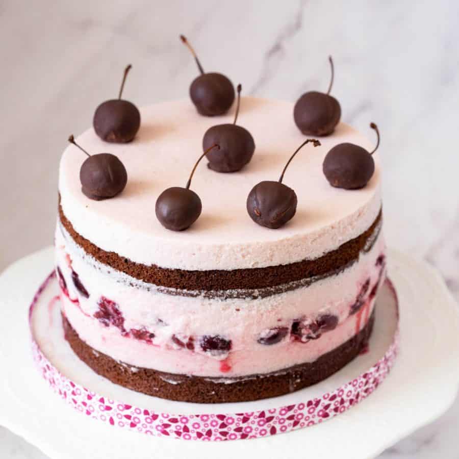 A chocolate cherry mousse cake on the cake stand.