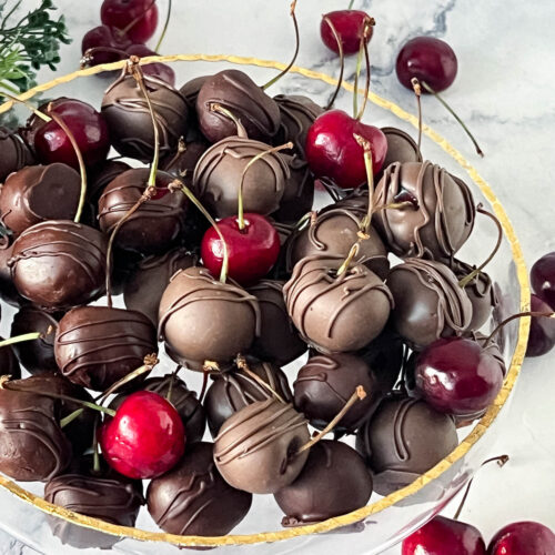 A platter with chocolate dipped cherries.