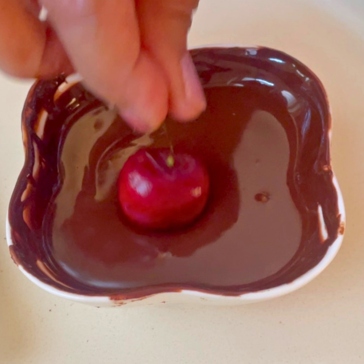 Dipping cherries in dark chocolate.