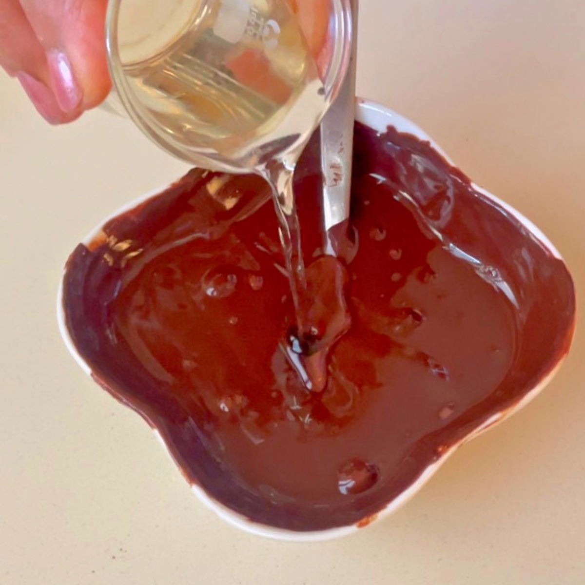 Adding coconut oil to dark chocolate for dipping.