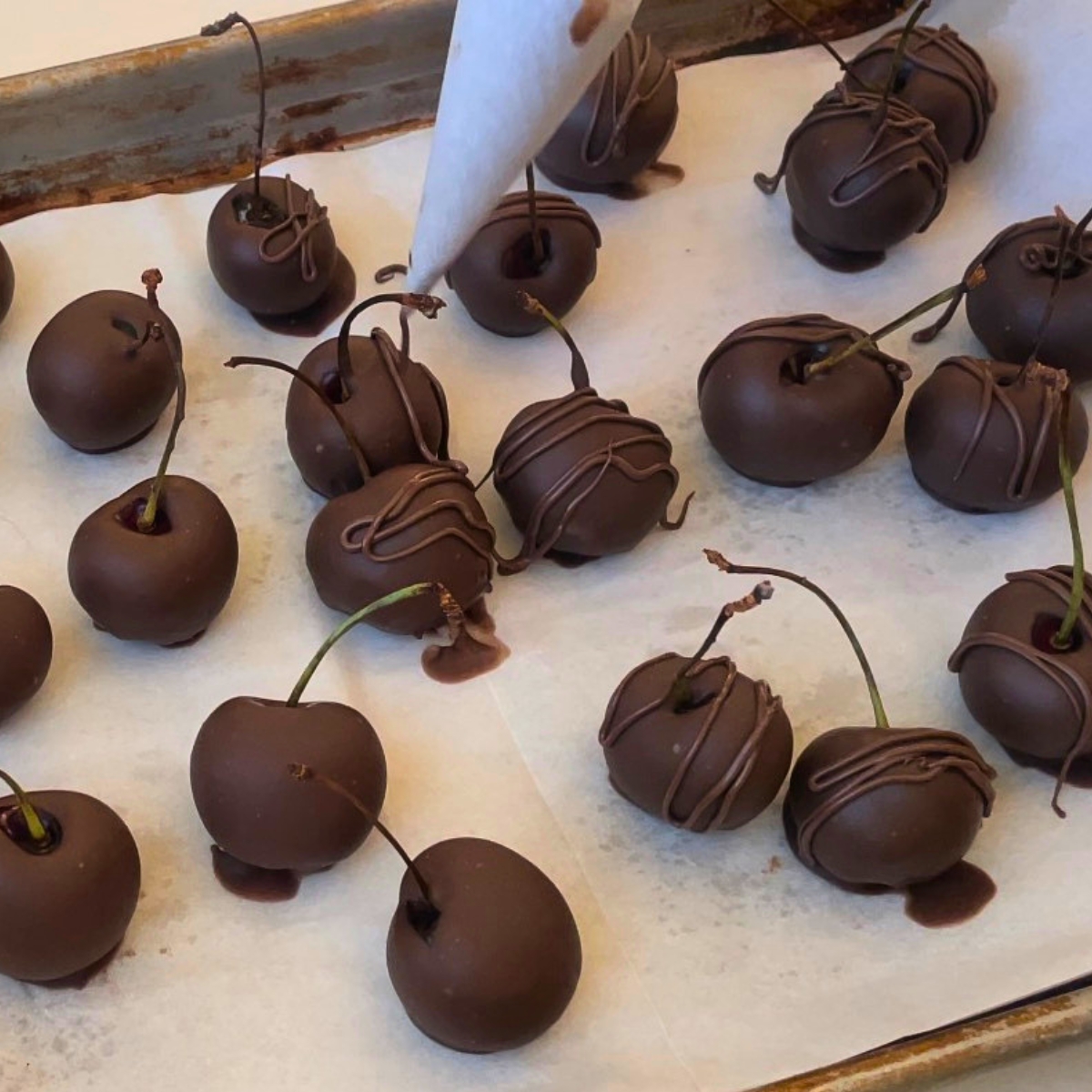 Decorating the chocolate covered cherries on the tray.