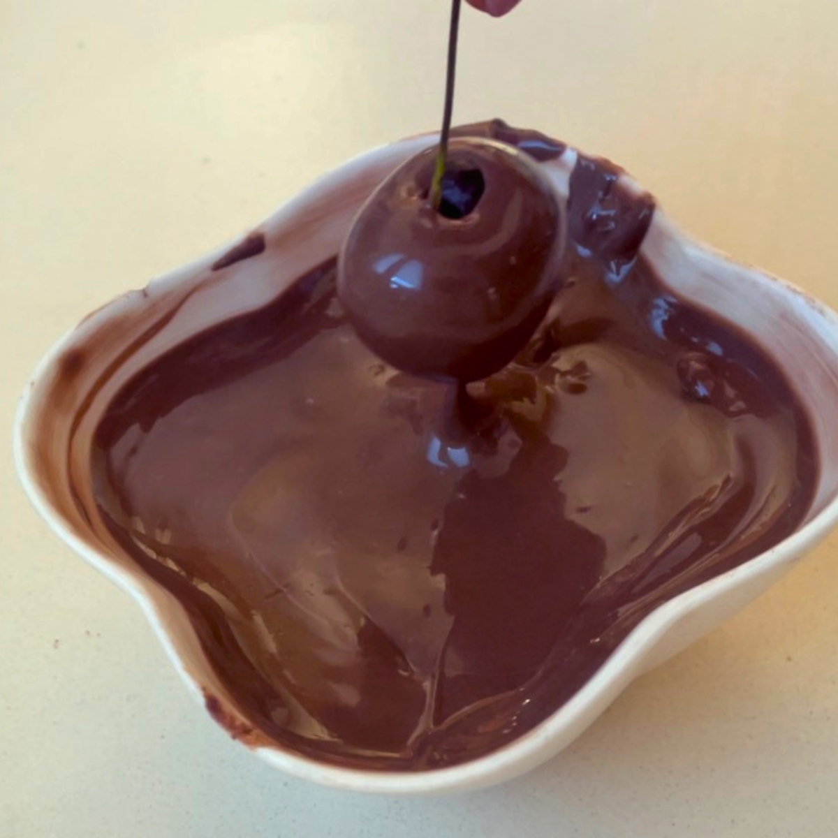 Dipping cherries in milk chocolate.