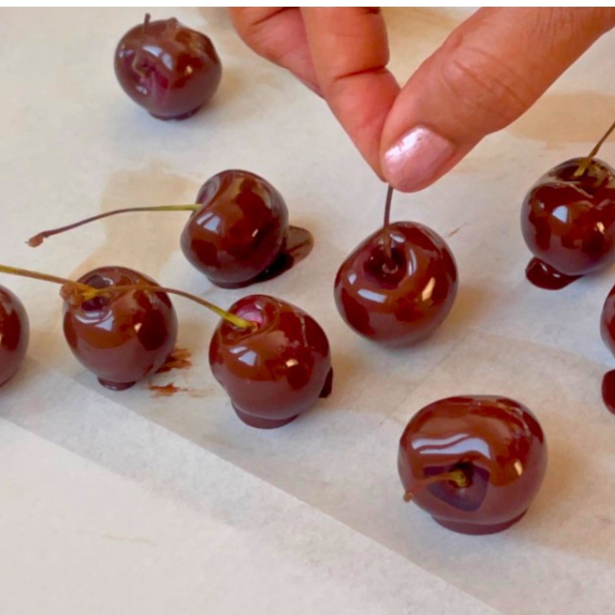 Placing chocolate covered cherries on the tray.