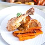 A marinated chicken on the plate with veggies.