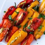 A plate with stuffed cheese mini peppers.