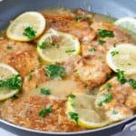 A pan with skillet chicken and lemon sauce.
