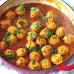 A cast iron skillet with meatballs.