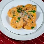 A plate with ravioli and pasta sauce.