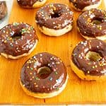 Glazed donuts on a wooden board.