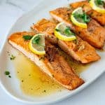 A platter with pan seared salmon fillets.