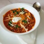 A white bowl with ground beef lasagna soup.