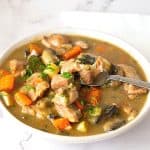 A bowl with turkey stew and a spoon.