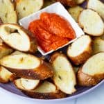 A plate with crostini and roasted red pepper spread.