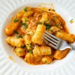 A plate with potato gnocchi and tomato sauce.