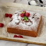Raspberry cake dusted with powdered sugar on the tray.