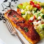 A plate with salmon and salad.