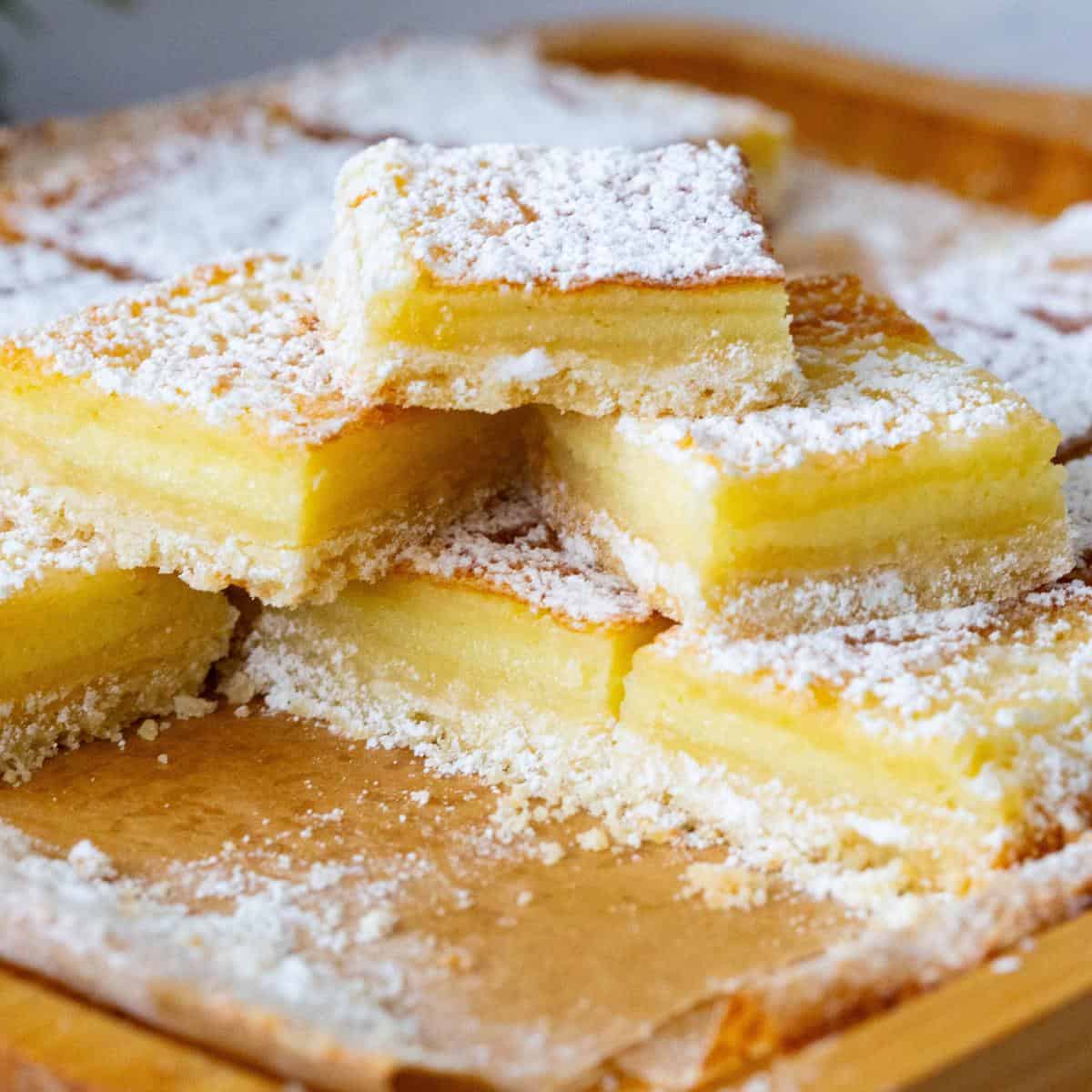 Yellow lemon bars on the table in a stack.