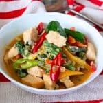 A white bowl with Thai salmon curry.
