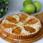 A baked Frangipani tart on the wooden board.