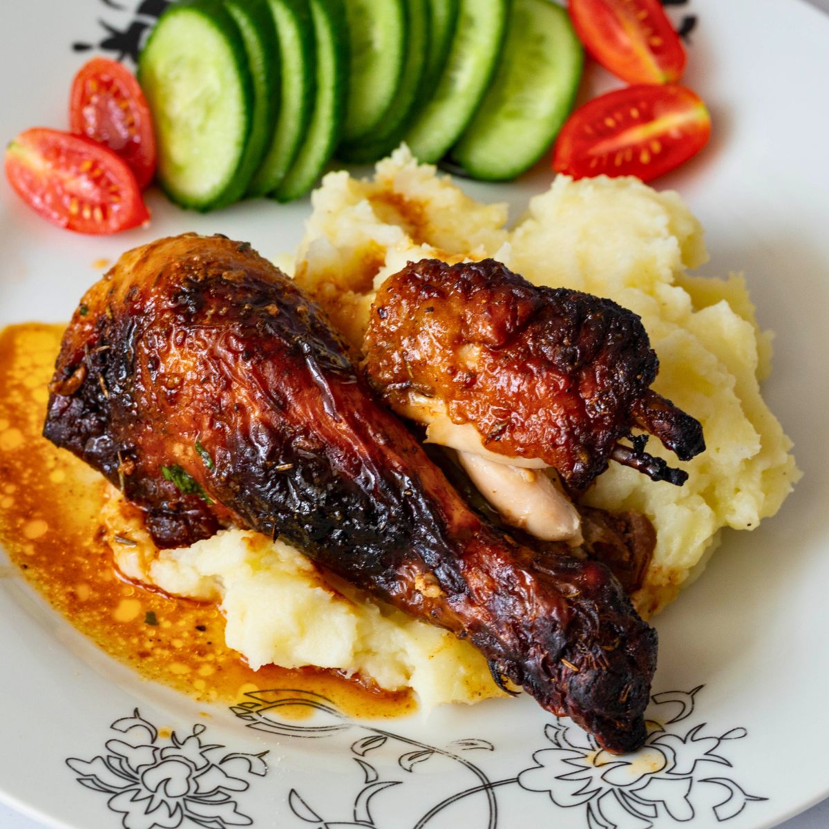 Roast chicken leg on mashed potatoes.