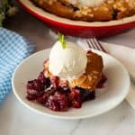 A plate with berry cobbler with ice cream.