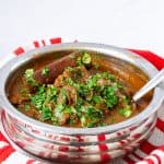 A stainless steel pot with beef curry.