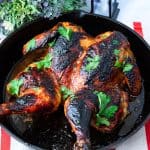 A cast iron skillet with spatchcock chicken.
