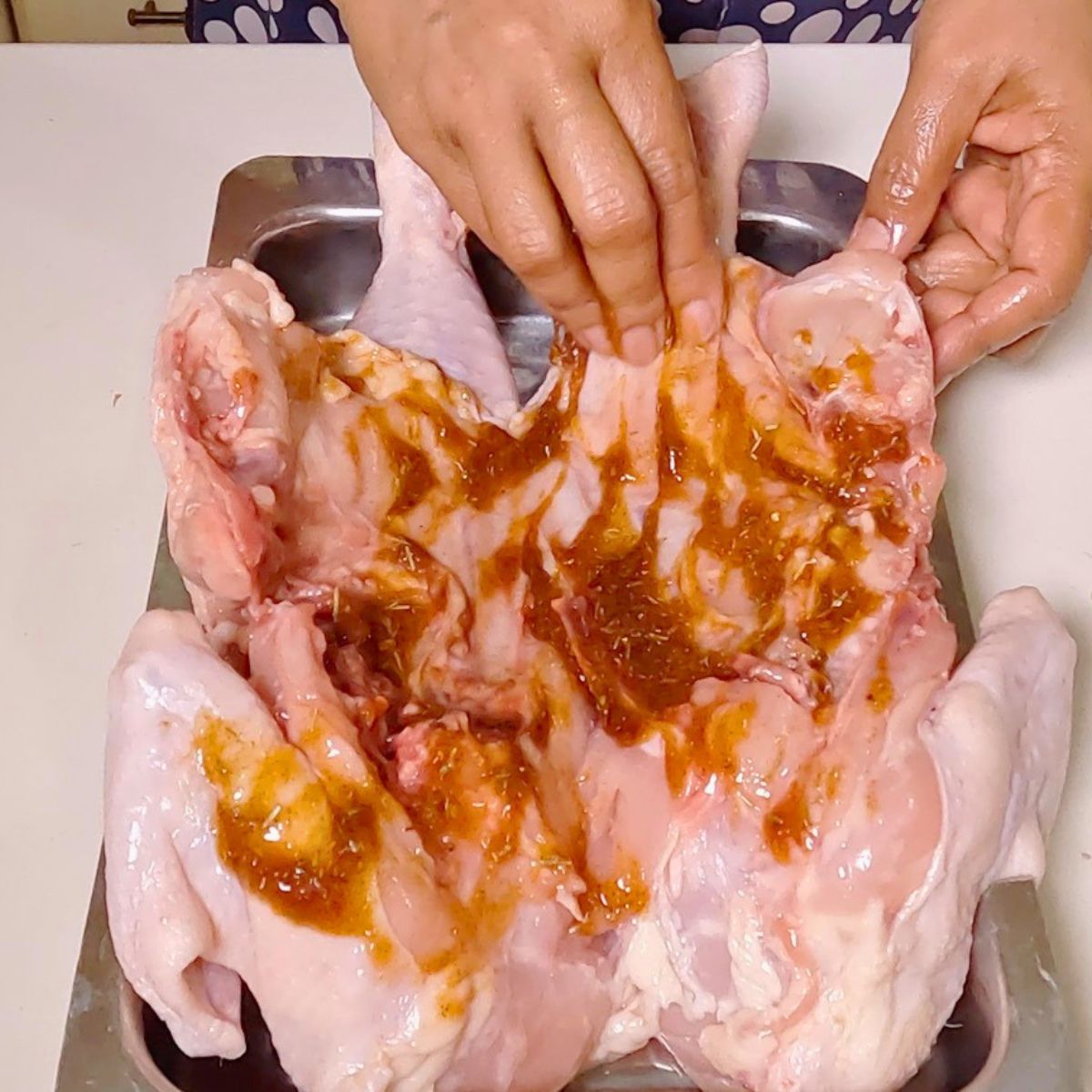 Marinating a roast chicken on the table.