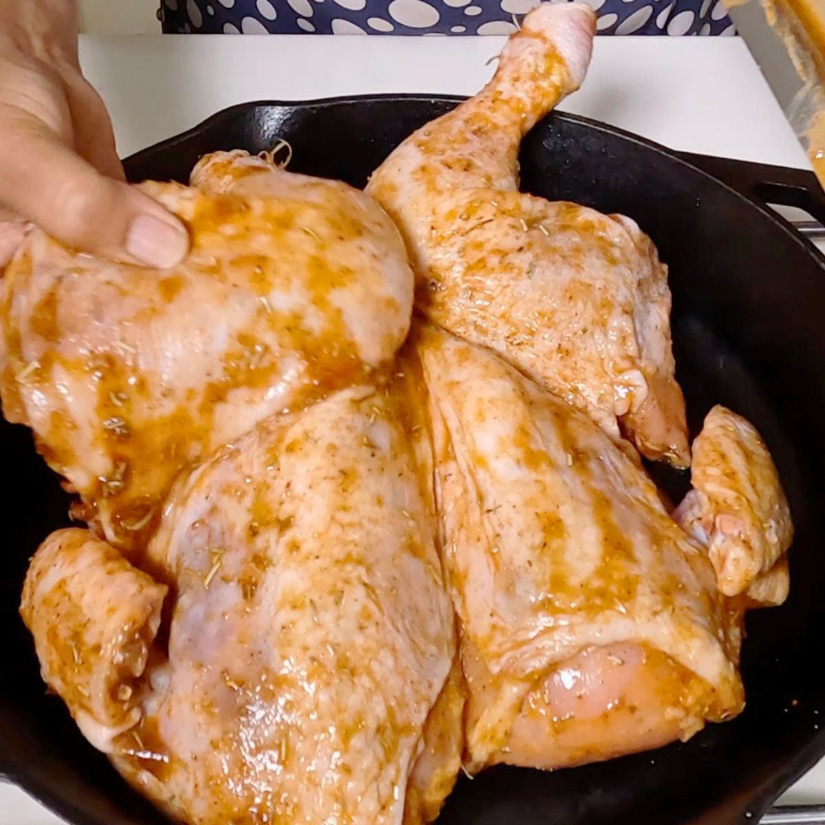 A Cast Iron pan with marinated roast chicken.