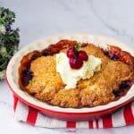 A pie dish with cherry cobbler.