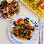 A table set up for rice, kebabs, and pita bread.