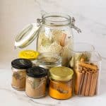 Jars of spices and rice with cinnamon bay leave and cloves.