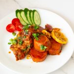 A plate with chicken thighs, sweet potato and salad.