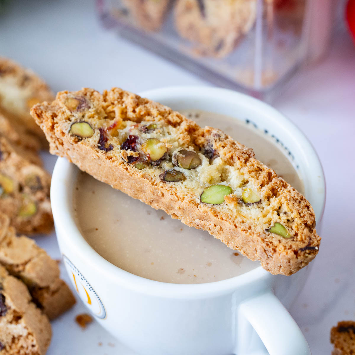 A coffee cup with cranberry biscotti.