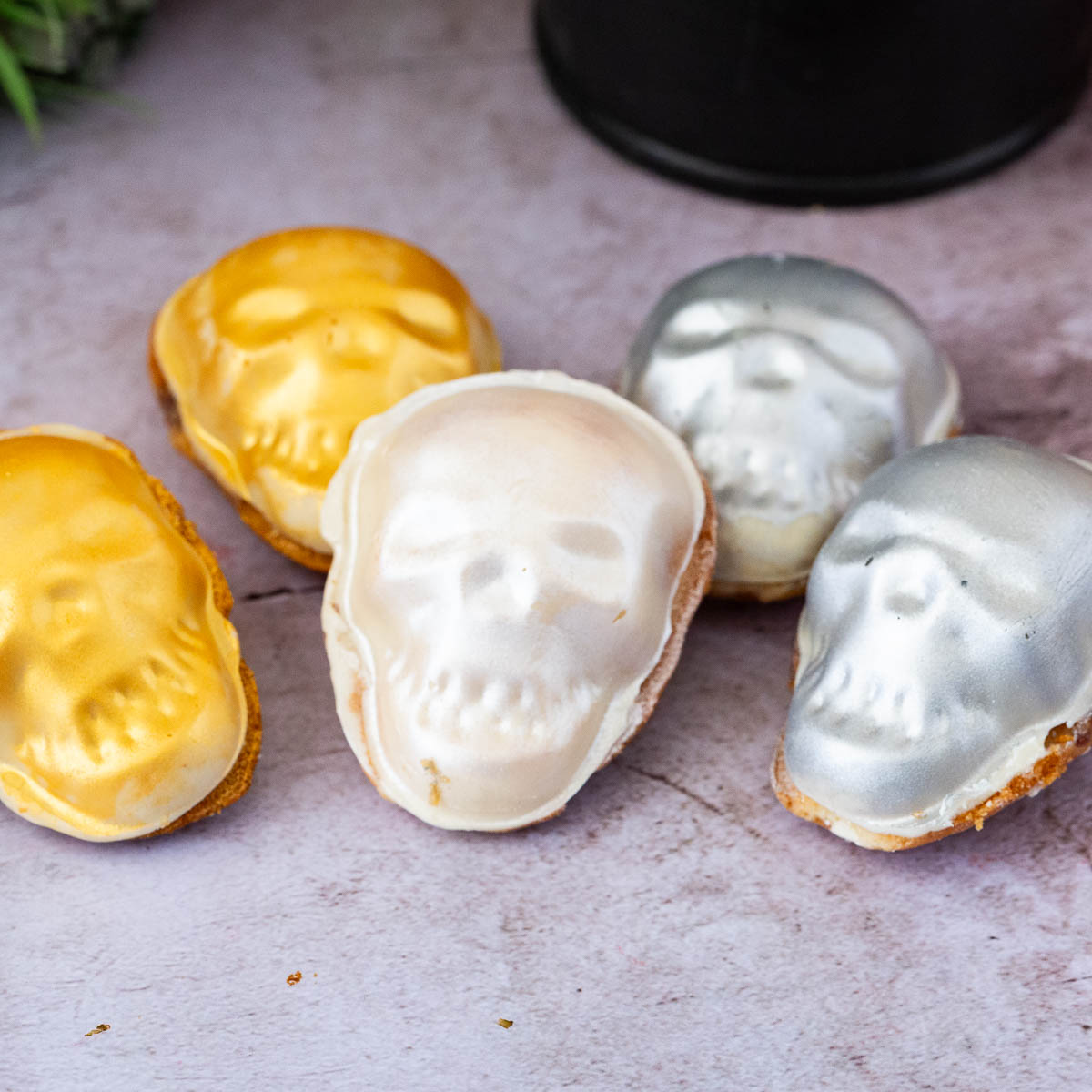 Skull shaped madeleines on a wooden board.