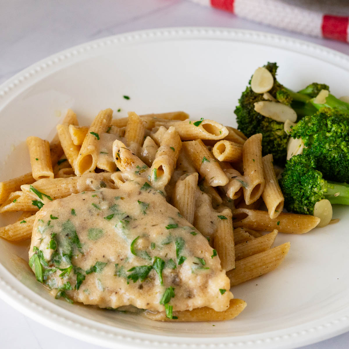 A plate with chicken cutlet and pasta.