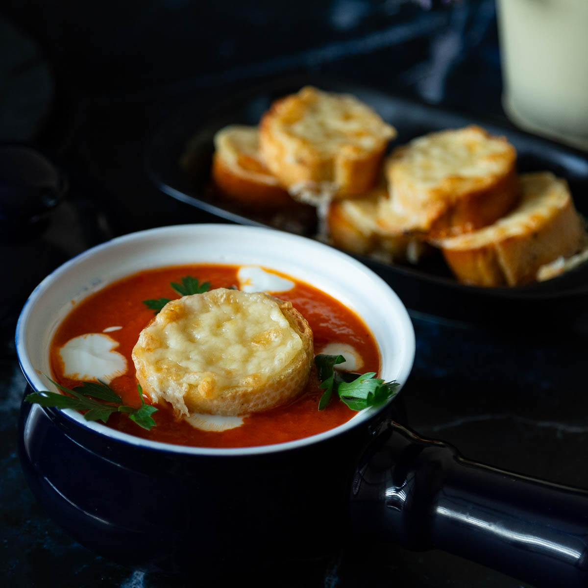 A bowl with red pepper and tomato soup.