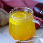 A glass mug with turmeric tea.
