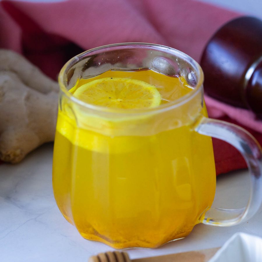 A glass mug with turmeric tea.