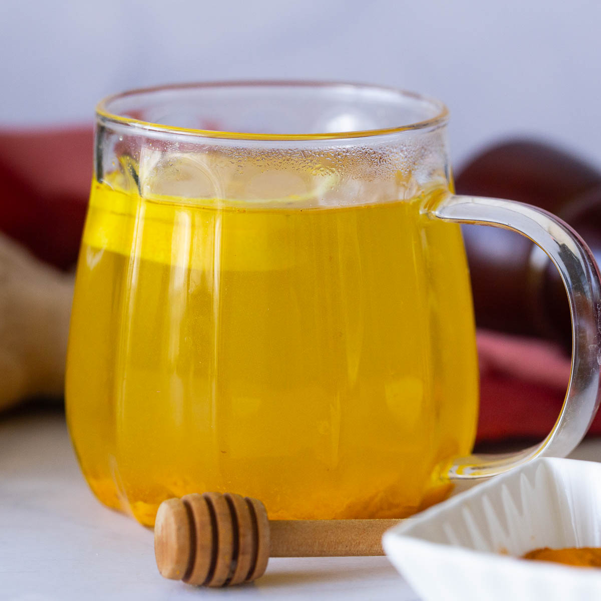 A glass cup with turmeric tea.