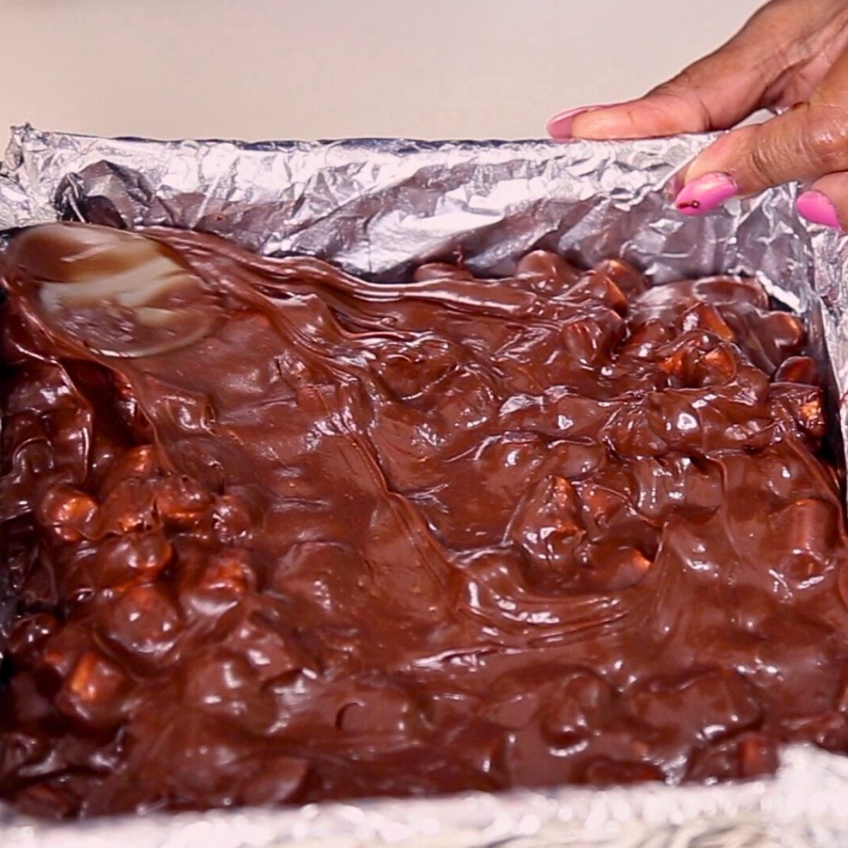 Progress pictures marshmallow fudge in a baking pan to set.