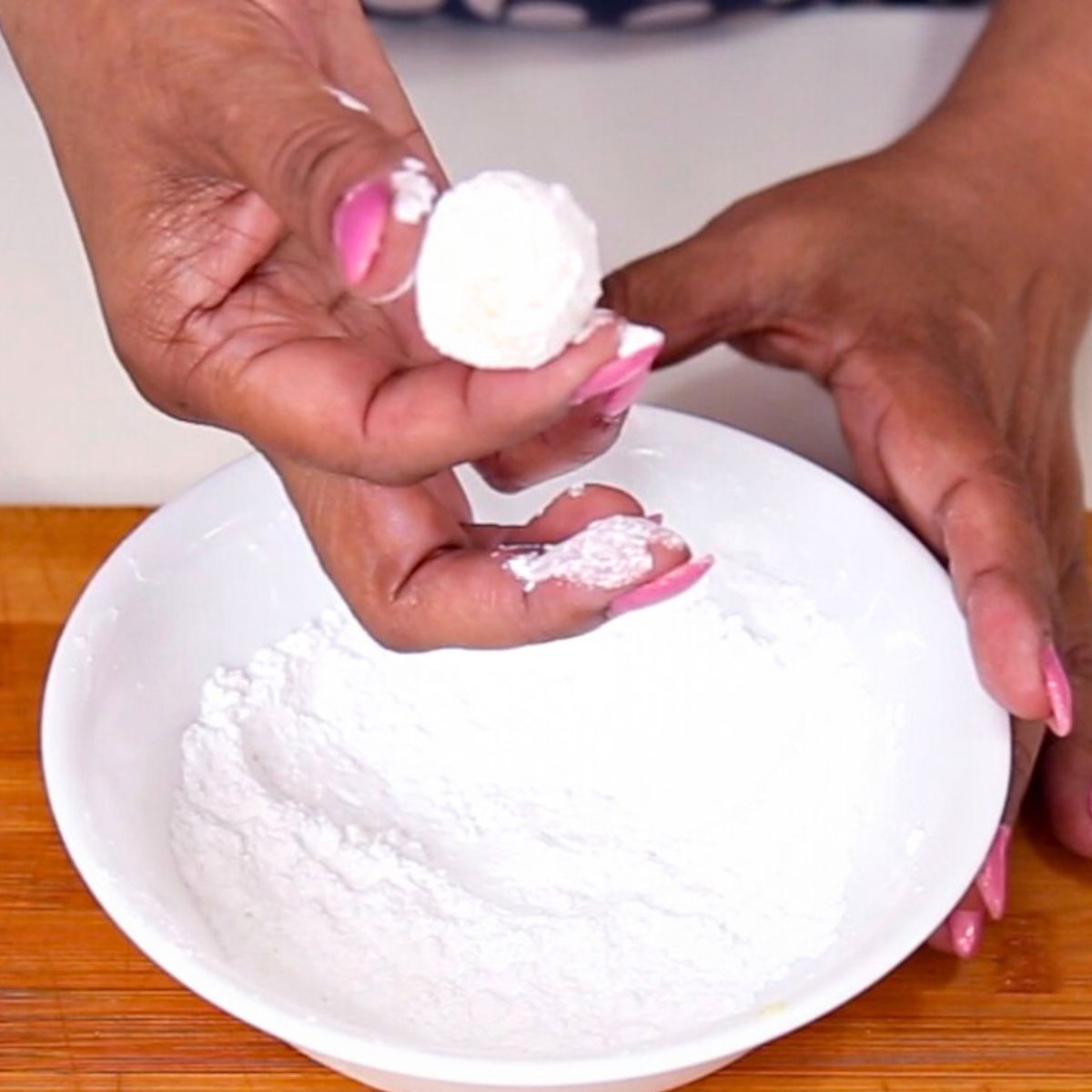 Coating the truffles with powdered sugar.